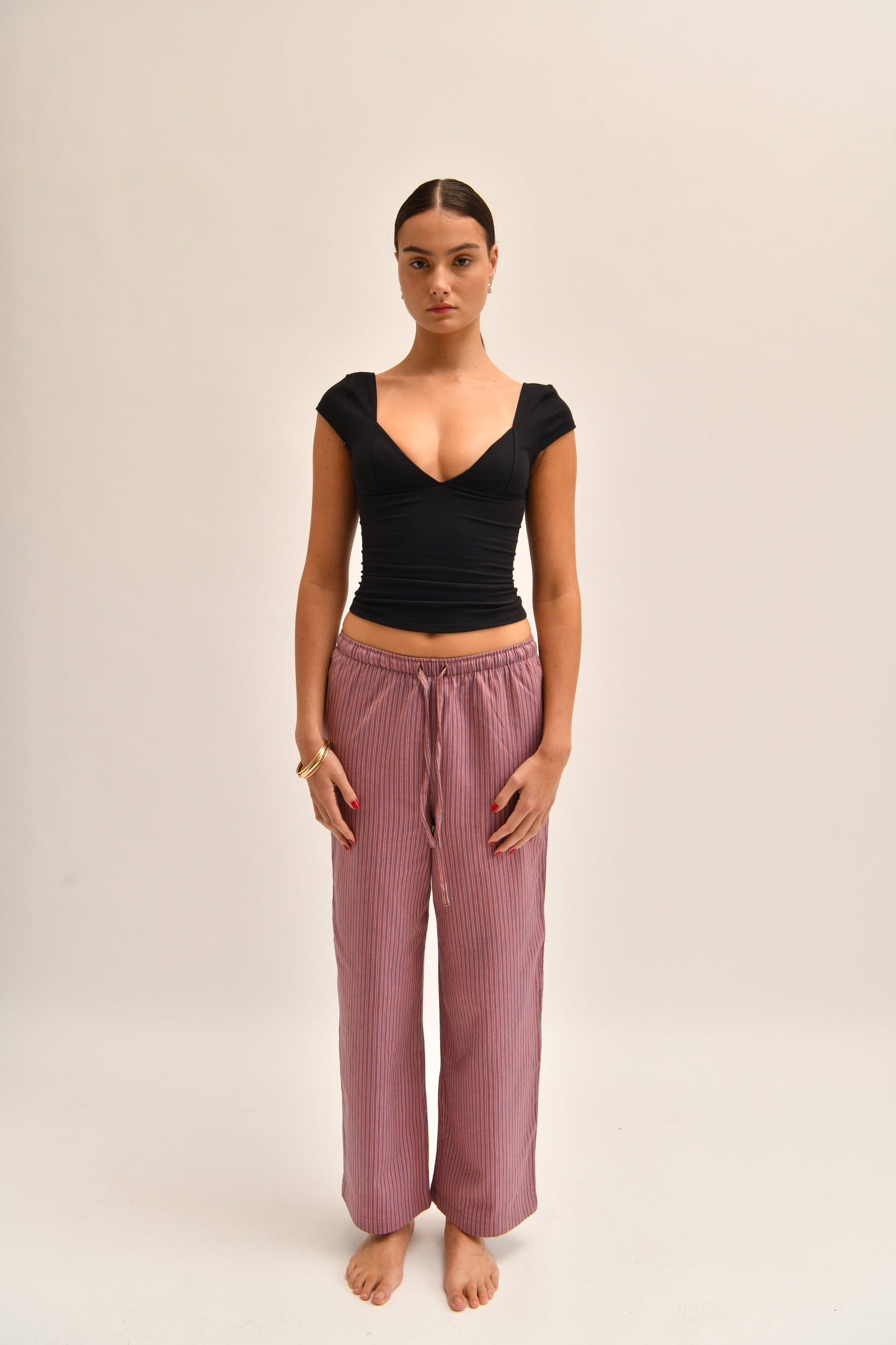 Front image of striped cotton trousers with a relaxed, wide-leg fit, designed to mimic the breezy look of linen.