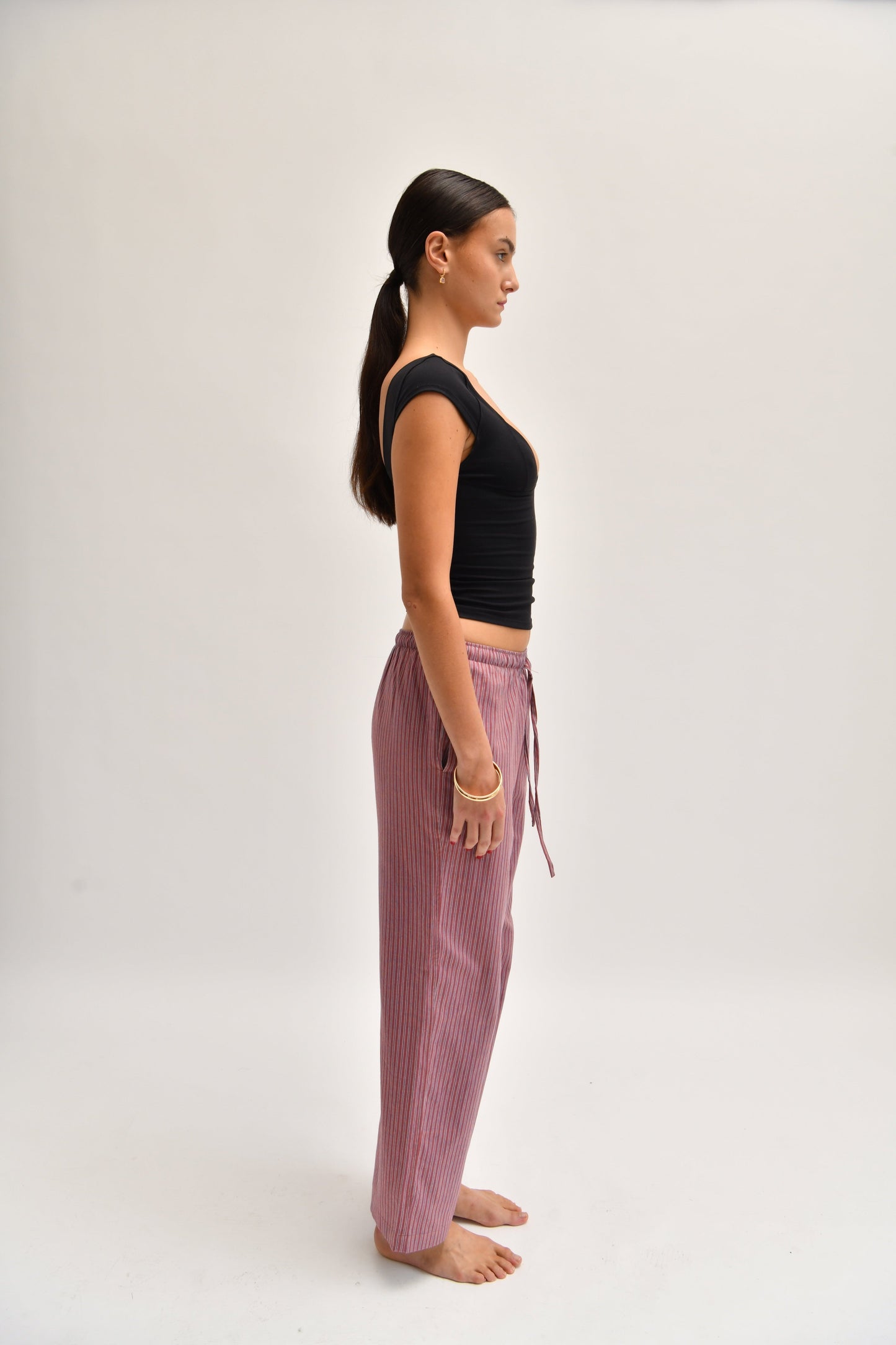 Side image of striped cotton trousers with a relaxed, wide-leg fit, designed to mimic the breezy look of linen.